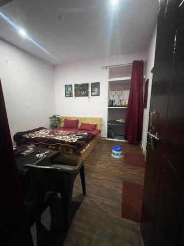 a room with a bed and a table in it at the kasar devi stays in Almora