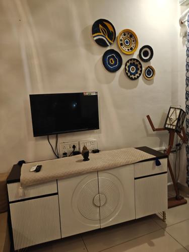 a living room with a tv on a wall at Sunils villa with private pool, Machan and play area in Karjat in Karjat