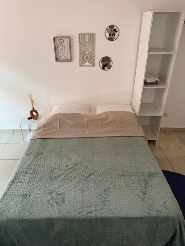 a bedroom with a bed with a green blanket on it at Tropical Mood city apartment 6 people in Grand-Bourg