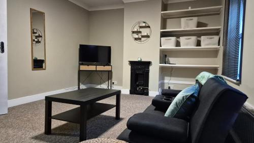 a living room with a couch and a tv and a table at Modern Stylish Flat - Free Parking - Near London in Reading