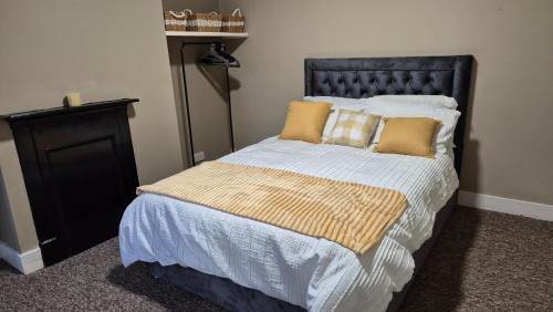 a bedroom with a large bed with yellow pillows at Modern Stylish Flat - Free Parking - Near London in Reading