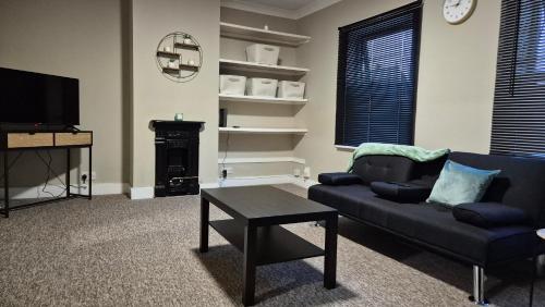 a living room with a couch and a table and a tv at Modern Stylish Flat - Free Parking - Near London in Reading