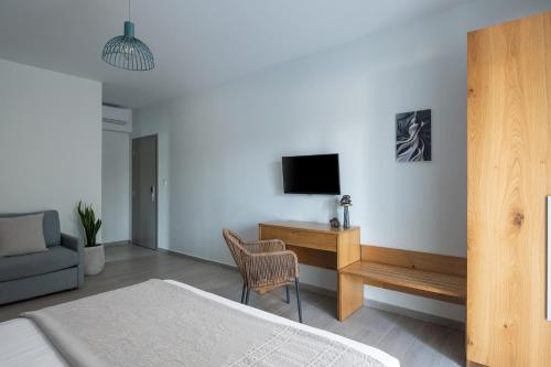 a bedroom with a bed and a tv on a wall at Leon Villas in Nikiti