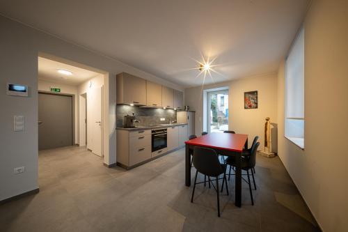 a kitchen and dining room with a table and chairs at Naturpark Gîte Al Schoulwunneng Sir in Boulaide