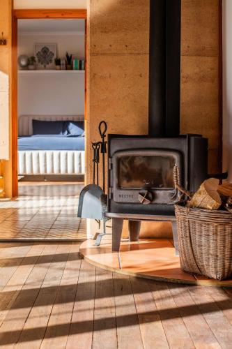 a fireplace in a living room with a bed at Stirling Creek Cottage in Stirling