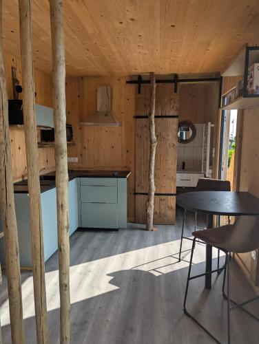 a kitchen with wooden walls and a table and chairs at Un rêve qui devient réalité in Zilling