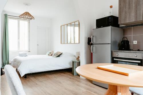 een kleine keuken met een tafel en een koelkast bij Washington 1 in Le Havre