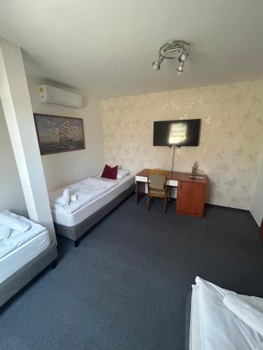 a hotel room with two beds and a desk at Brasserka in Nitra