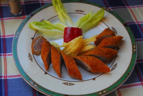 a plate of food with sausage and french fries at Apartamentos Paraje San Gines in Andújar