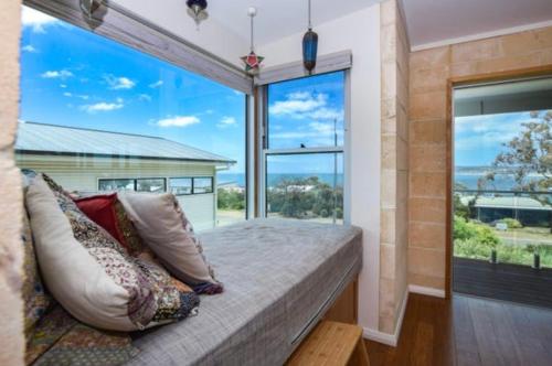 a bedroom with a large window and a bed with pillows at Emu Bay Bliss 'sweeping ocean views' in Emu Bay