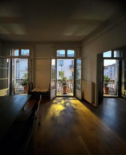 une chambre vide avec des portes s'ouvrant sur un balcon dans l'établissement Apartment Joie de Vivre, à Béziers