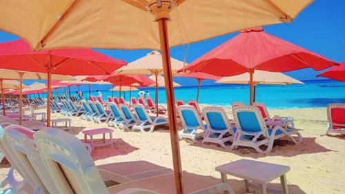 a bunch of chairs and umbrellas on a beach at Porto Matrouh Unique Chalet 81001 in Marsa Matruh