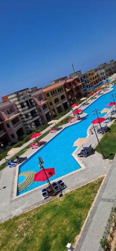 a large pool with chairs and umbrellas in a resort at Porto Matrouh Unique Chalet 81001 in Marsa Matruh