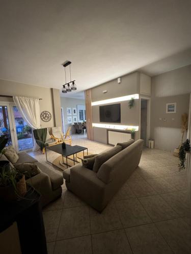 a living room with two couches and a tv at Casa Negiada in Agios Nikolaos