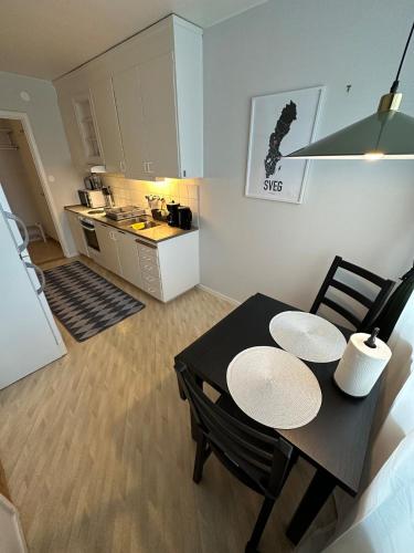 a dining room table with two chairs and a kitchen at Centralt lägenhet i Sveg in Sveg