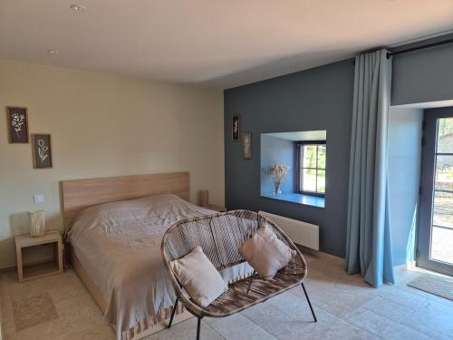 une chambre avec un lit et une chaise dedans dans l'établissement Magnifique maison de famille rénovée, à Saint-Romain