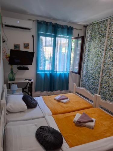 two beds in a room with blue curtains at Joković Accommodation in Kotor