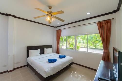 a bedroom with a bed and a ceiling fan at Baan Faa Talaychan Resort in Chao Lao Beach