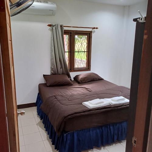 a small bed in a room with a window at Lamai viking bungalow in Koh Samui