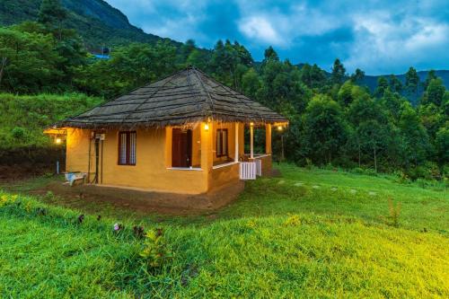 a small house in a field with lights on it at FOOD FOREST KANTHALLOOR in Kanthalloor