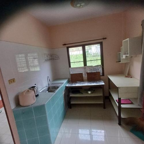 a small kitchen with a sink and a window at Lamai viking bungalow in Koh Samui