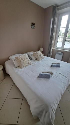 - un grand lit blanc avec 2 serviettes dans l'établissement Ty Dahouet Bretagne, à Pléneuf-Val-André