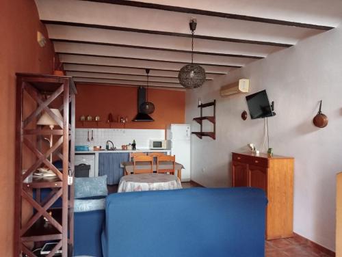 a living room with a blue couch and a kitchen at Casa Rural El Balcón de Cazorla in Tiscar
