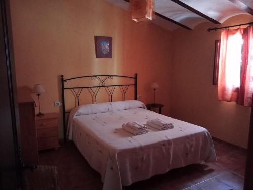 a bedroom with a bed with a white blanket at Casa Rural El Balcón de Cazorla in Tiscar