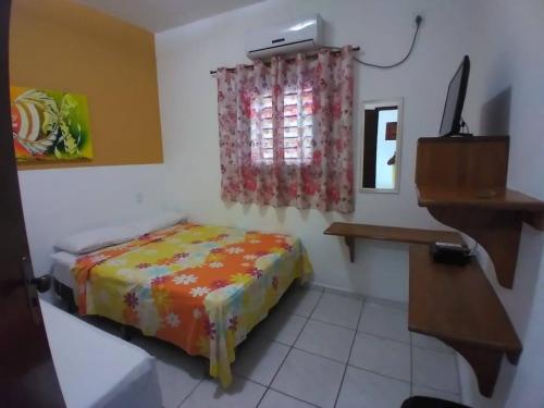 a small bedroom with a bed and a window at Chalés do Otto e Karine in Canoa Quebrada