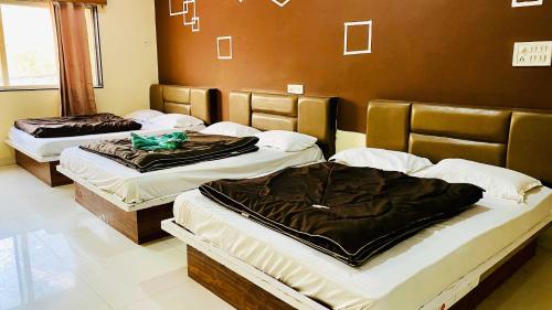 three beds sitting in a room at Hotel Palash in Godarpura