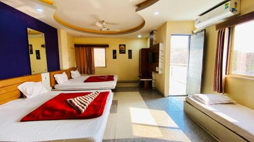 a hotel room with two beds and a tv at Hotel Palash in Godarpura