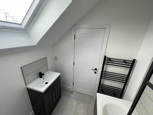a bathroom with a sink and a mirror at Brand New High Spec House with Parking & Wi-Fi By Home Away From Home - B in Newcastle under Lyme