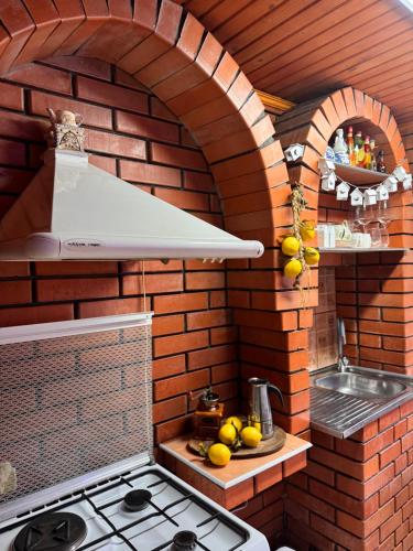 a kitchen with a stove and a brick wall at Casa MAYA in Solotvyno
