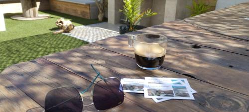 une table avec une tasse de café et une paire de lunettes dans l'établissement Escapade à la plage, à Le Portel