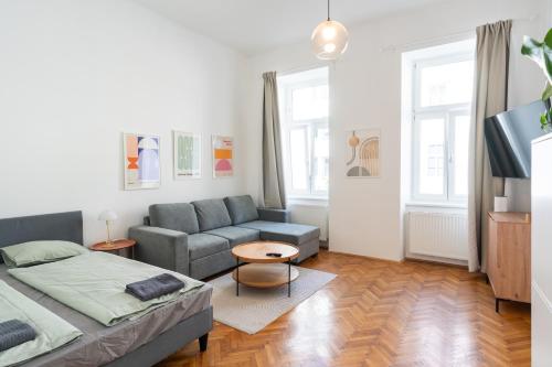 a living room with a bed and a couch at Premium Suites Vienna - City Stay in Vienna