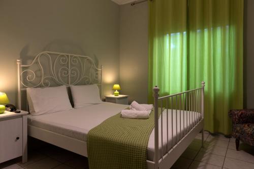 a bedroom with a bed with a green curtain at Electra Apartments & Studios 2 in Keramoti