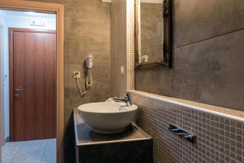 a bathroom with a sink and a phone on the wall at Electra Apartments & Studios 2 in Keramoti