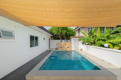 an indoor swimming pool in a house with a wooden ceiling at Baan Faa Talaychan Resort in Chao Lao Beach