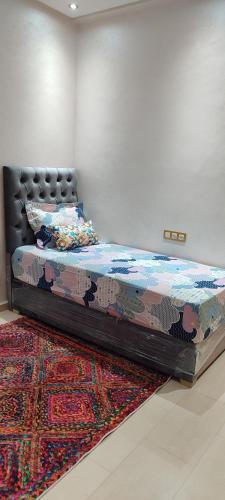a bed in a room with a rug at Dar lala soukaina in Marrakesh