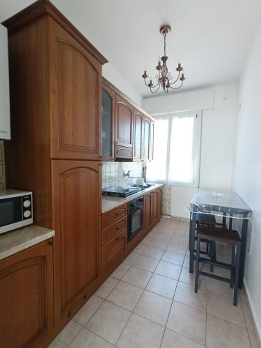 a kitchen with wooden cabinets and a table in it at Belemi's House 