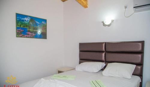 - une chambre avec un lit doté d'une tête de lit marron dans l'établissement Lotos - family stan, à Bar