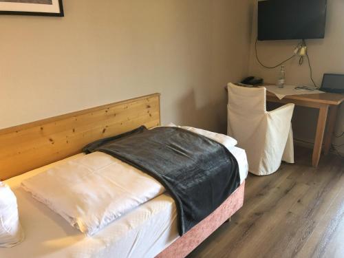 a bedroom with a bed and a table with a desk at Schlossberghof Marzoll in Bad Reichenhall