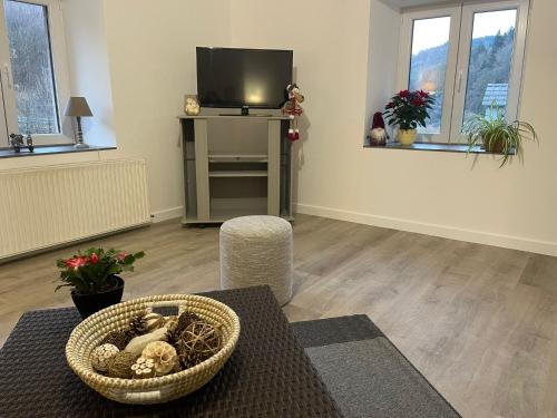 un salon avec une télévision et un panier avec des animaux en peluche dans l'établissement Au Pied du Donon, à Grandfontaine