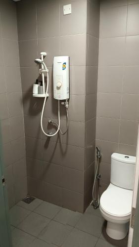 a bathroom with a white toilet and a shower at Summer Suites KLCC by CozyNest in Kuala Lumpur
