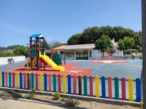 a playground with a colorful fence in a park at Casa do beco Martinho in Viana do Castelo