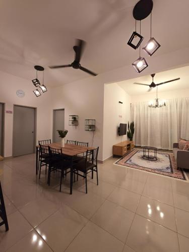 a dining room and living room with a table and chairs at Homestay D'Casa, Apartment In Sepang, KLIA in Sepang