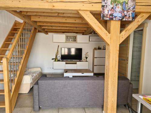 a living room with a staircase and a television at Petite maison meublée entre Avignon et Carpentras in Morières-lès-Avignon