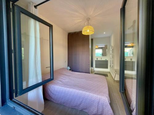 une chambre avec un lit et une grande fenêtre dans l'établissement Charmant T2, centre village, à Vallon-Pont-dʼArc