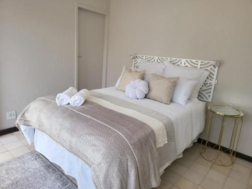 a bedroom with a large bed with white sheets and pillows at Villa Francisco Bed & Breakfast Solar Power in Germiston