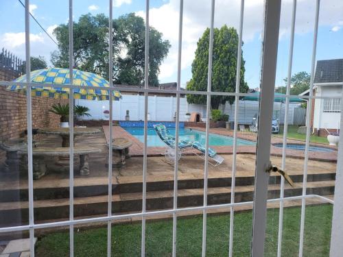 a view of a pool through a fence at Villa Francisco Bed & Breakfast Solar Power in Germiston